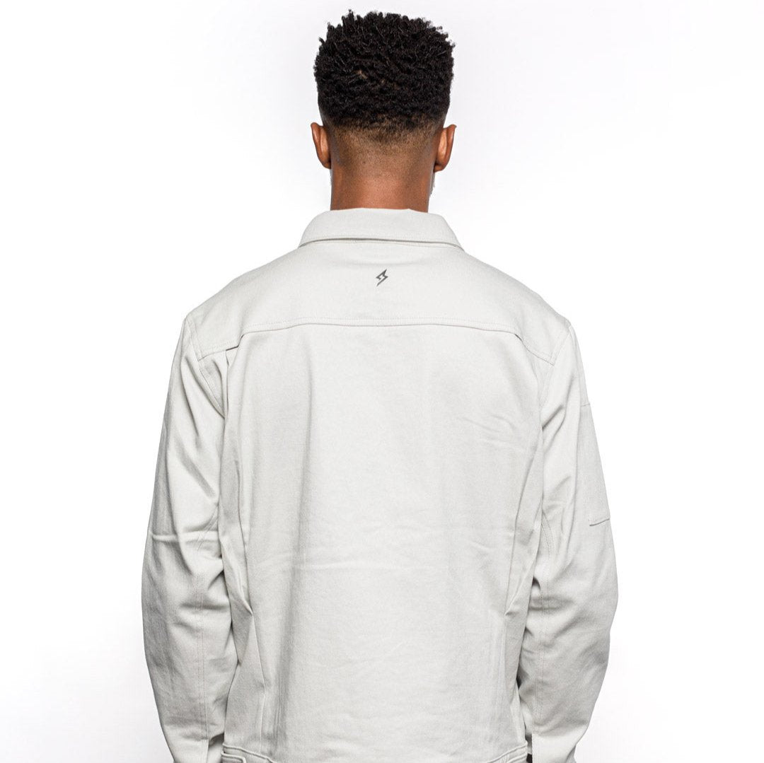 Back view of Male model wearing Anvil Chore Jacket in chalk colorway. @color_chalk