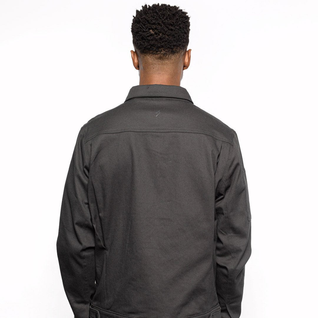 Back view of Male model wearing Anvil Chore Jacket in gravel colorway. @color_gravel