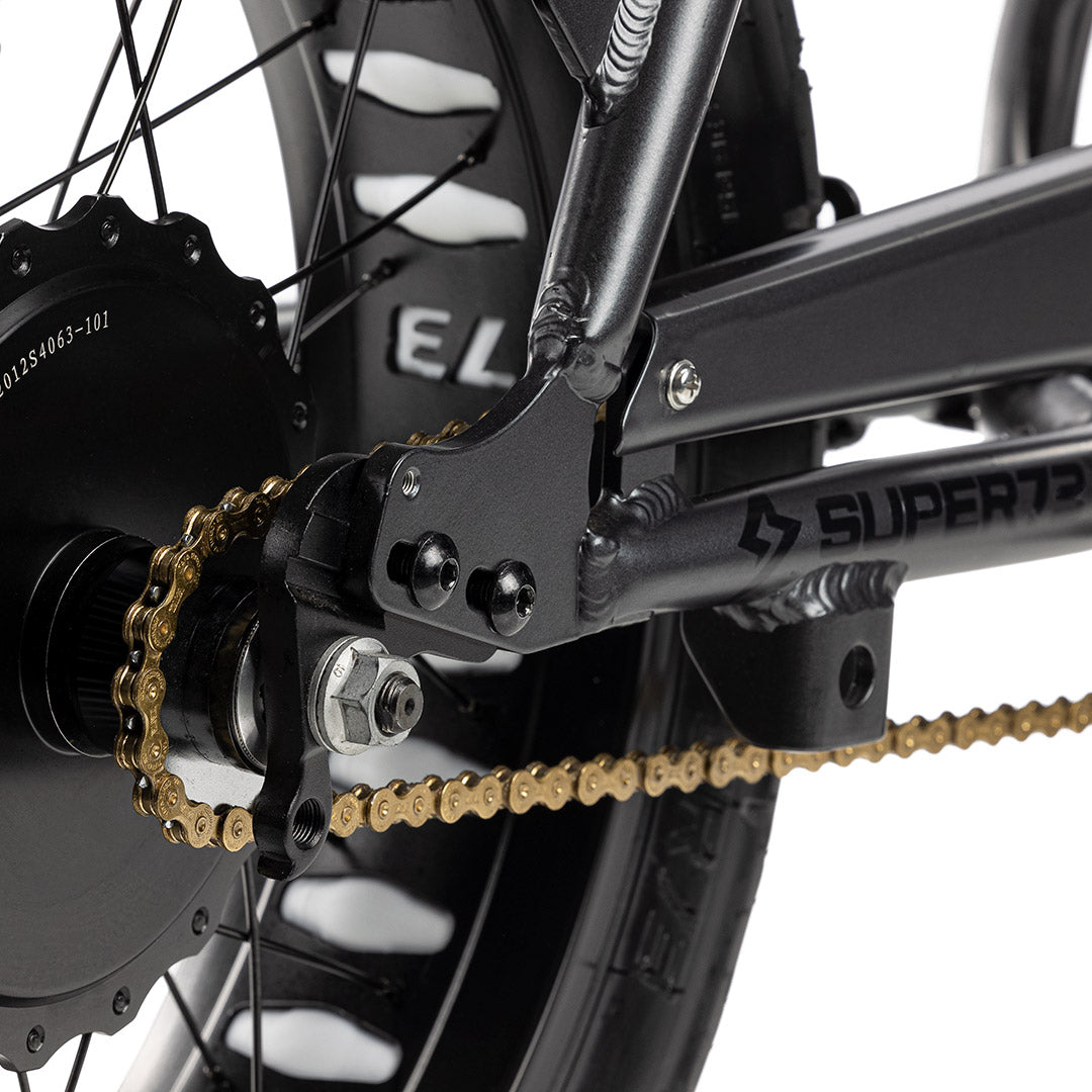 Close up shot of gold chain on bike with a white background. @color_gold