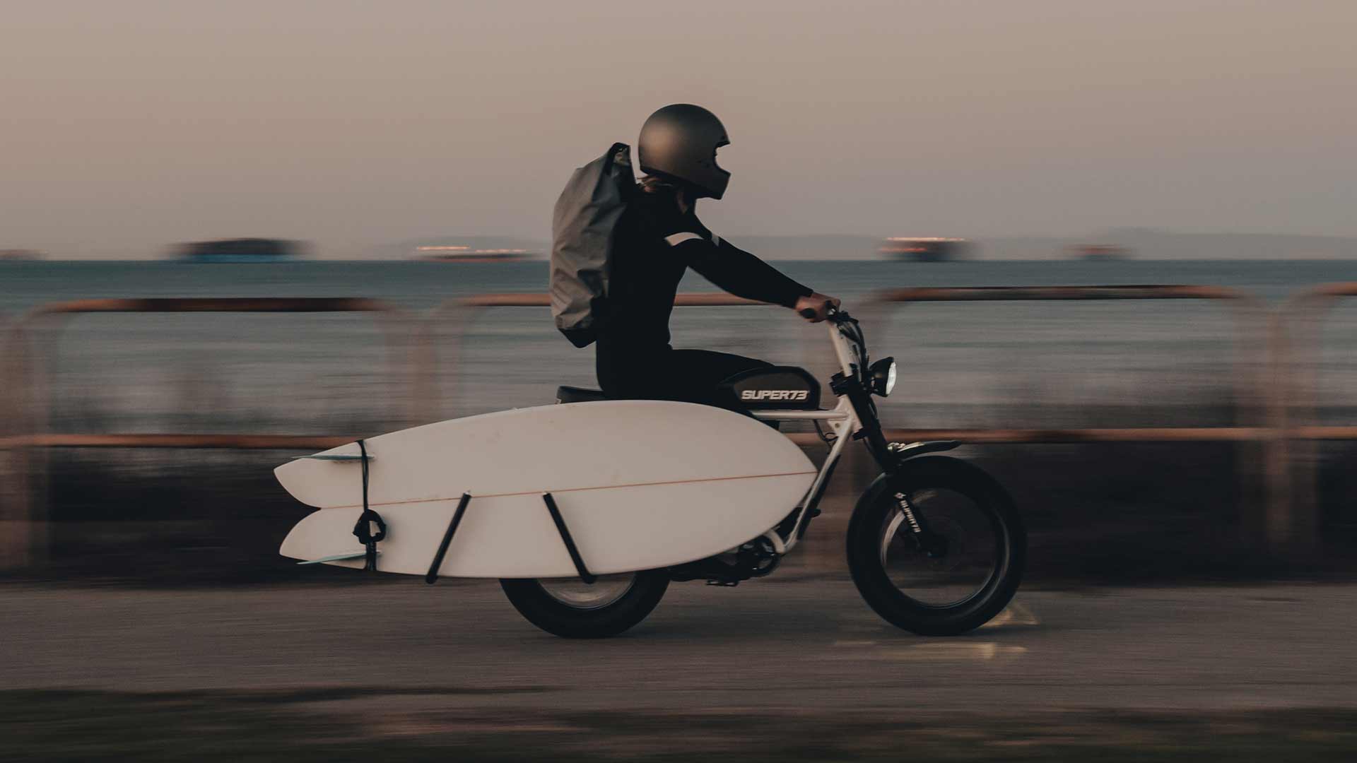 Rider hauling their surfboard on their SUPER73 using an MBB surf rack.