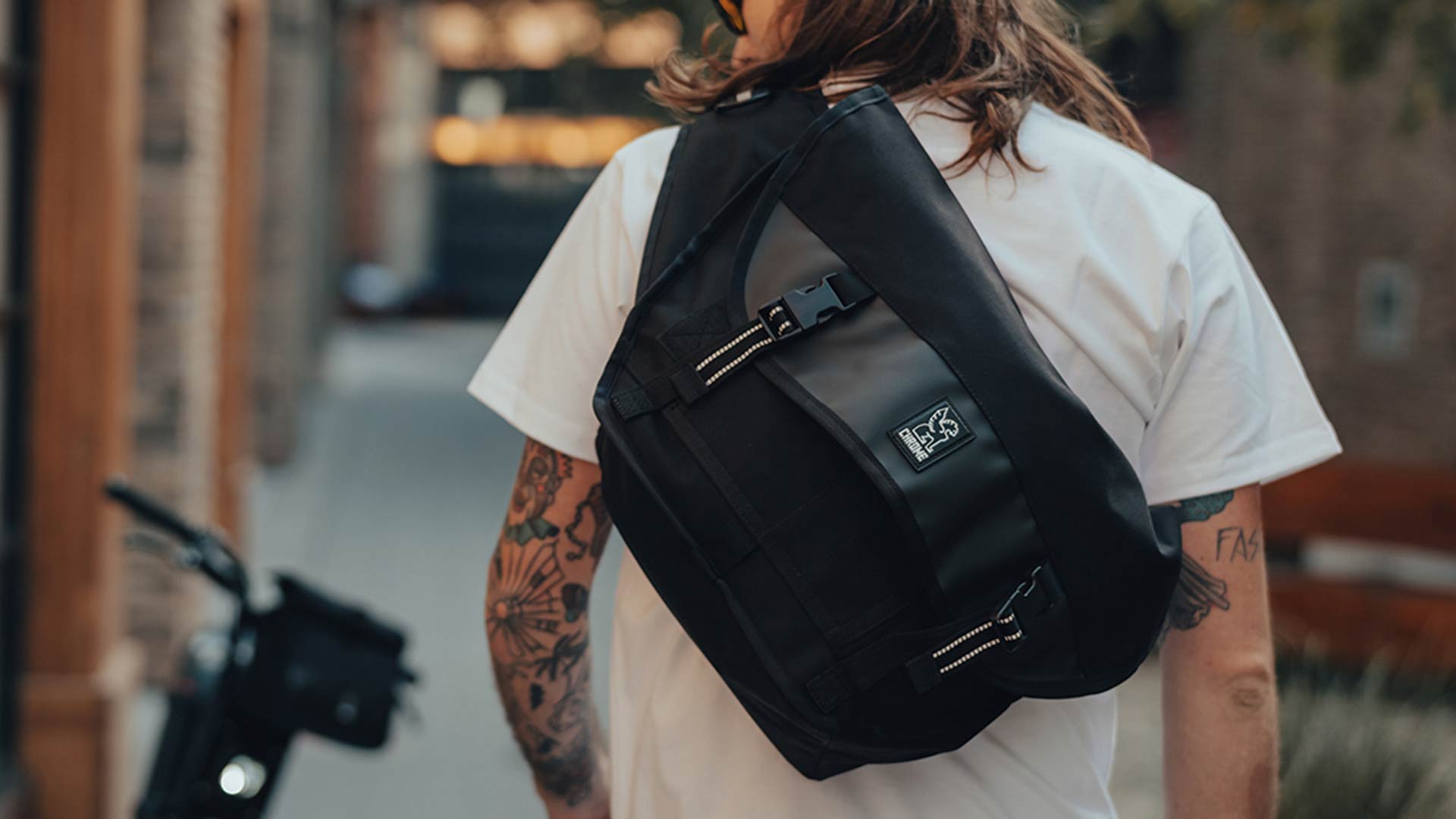 A rider wearing a chrome bag while commuting on their SUPER73 e-bike