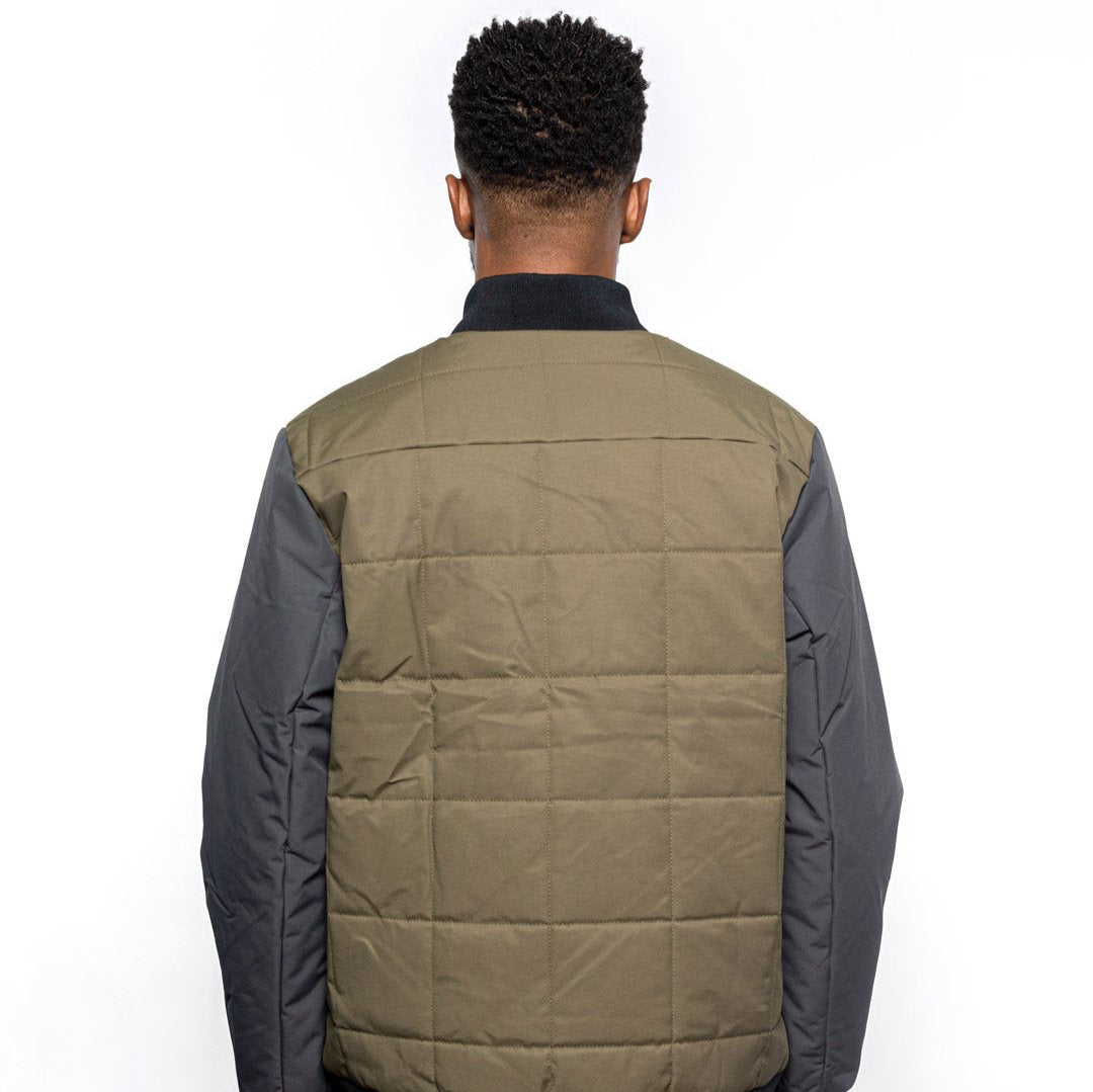 Back view of Male model wearing Sipes Varsity Jacket in dark fatigue colorway. @color_dark fatigue