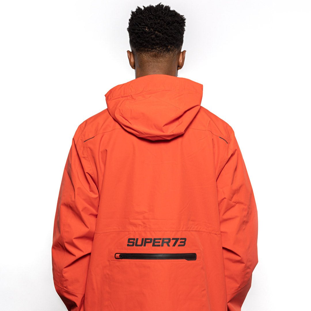 Back view of Male model wearing Vale Packable Anorak in blood orange colorway. @color_blood orange